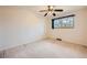 Spacious bedroom with neutral carpet, ceiling fan and a window overlooking the yard at 2056 S Newark Way, Aurora, CO 80014