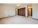 Spacious bedroom with neutral carpet, ceiling fan, closet, and a door that leads to the bathroom at 2056 S Newark Way, Aurora, CO 80014