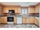 Bright kitchen features wood cabinets, black appliances, and neutral countertops at 2056 S Newark Way, Aurora, CO 80014