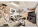 Basement with a stone accent wall and a cozy seating area with a large television at 7060 Avrum Dr, Denver, CO 80221