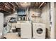 Unfinished basement with washer, dryer, utility sink, and exposed pipes; ready for customization at 7060 Avrum Dr, Denver, CO 80221