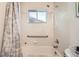 Full bathroom with a white tiled shower and tub combination and a neutral patterned shower curtain at 7060 Avrum Dr, Denver, CO 80221