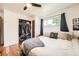 Bright bedroom features hardwood floors, a ceiling fan, a large window, and a walk-in closet at 7060 Avrum Dr, Denver, CO 80221