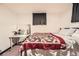 Bedroom features a patterned quilt, a desk with a mirror, and window with dark drapes at 7060 Avrum Dr, Denver, CO 80221