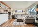 Bright living room featuring hardwood floors, an oversized window, and views into the kitchen at 7060 Avrum Dr, Denver, CO 80221