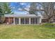 Large backyard features mature trees and an enclosed back porch with lots of natural light at 3335 S Verbena Ct, Denver, CO 80231