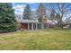 Large backyard with mature trees and partially enclosed sunroom addition on the house at 3335 S Verbena Ct, Denver, CO 80231
