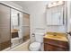 Bathroom with shower/tub combo with sliding glass doors, single sink vanity, and matching medicine cabinet at 3335 S Verbena Ct, Denver, CO 80231