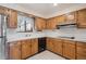 Cozy kitchen featuring wood cabinets, modern appliances, and a white backsplash at 3335 S Verbena Ct, Denver, CO 80231