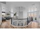 Upstairs hallway with wood floors, modern railings, circular ceiling accent, and a partial view of living room at 10624 Ladera Pt, Lone Tree, CO 80124