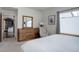 Bright bedroom with a dresser, mirror, chair, and a window that brings in natural light at 1316 Snowberry Ln # 101, Louisville, CO 80027