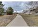 Paved walking path leading through the neighborhood near grassy areas and trees at 1316 Snowberry Ln # 101, Louisville, CO 80027