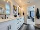 This bathroom features sleek, black accents, white countertops and cabinets, and a large mirror above the sink at 938 Larkspur Ln, Louisville, CO 80027