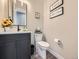 Stylish powder room featuring a modern vanity, a chic mirror, and tastefully decorated walls at 938 Larkspur Ln, Louisville, CO 80027