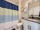 Well-lit bathroom featuring a shower with a blue striped curtain and a modern vanity at 938 Larkspur Ln, Louisville, CO 80027