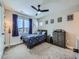 A colorful bedroom featuring a ceiling fan, large window, and multiple pieces of wall art at 938 Larkspur Ln, Louisville, CO 80027