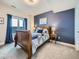 This bedroom features a wooden bed frame, a ceiling fan, and large windows for plenty of natural light at 938 Larkspur Ln, Louisville, CO 80027