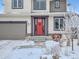 Welcoming home facade showcasing a vibrant red front door and a well-maintained landscape in a snow covered yard at 938 Larkspur Ln, Louisville, CO 80027