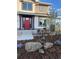 Charming front yard with a bright red front door, beautiful landscaping, flowers and seating at 938 Larkspur Ln, Louisville, CO 80027