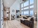 Spacious living room boasting a large window, high ceilings, a cozy fireplace, and a stylish sectional sofa at 938 Larkspur Ln, Louisville, CO 80027