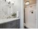 Chic bathroom with a modern vanity, decorative mirror, and a tiled shower at 1390 N Emerson St # 106, Denver, CO 80218