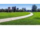 Scenic path through a lush green park with high rise apartments in the background at 1390 N Emerson St # 106, Denver, CO 80218