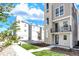 Modern three-story townhome with a stone accent tower, small balcony, and manicured lawn at 11205 W 53Rd Ln, Arvada, CO 80002