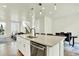 Kitchen island featuring stainless steel dishwasher, modern countertop and lighting, and seating at the breakfast bar at 11205 W 53Rd Ln, Arvada, CO 80002