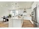 Bright, open kitchen featuring white cabinets, stainless steel appliances, and a spacious center island with bar seating at 11205 W 53Rd Ln, Arvada, CO 80002