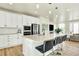 Open-concept kitchen with stainless appliances, an island with seating, and a view of the living area at 11205 W 53Rd Ln, Arvada, CO 80002