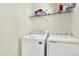 Convenient laundry room with a washer, dryer, and storage shelf at 11205 W 53Rd Ln, Arvada, CO 80002