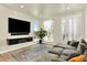Cozy living room with a large sectional sofa, wall-mounted TV, and modern shelving at 11205 W 53Rd Ln, Arvada, CO 80002