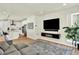 Open-concept living room flowing into a kitchen with a TV, modern shelving, and a large sofa at 11205 W 53Rd Ln, Arvada, CO 80002