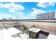 Relax on the rooftop patio with a hammock, cushioned seating, and a fire pit table, perfect for enjoying the views and clear sky at 11205 W 53Rd Ln, Arvada, CO 80002