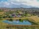 Aerial view of community pool with lake view, and distant houses in the background at 1280 Gentle Rain Dr, Castle Rock, CO 80109