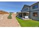 Enjoy this backyard oasis, featuring tiered landscaping, artificial turf, and hot tub under covered patio at 1280 Gentle Rain Dr, Castle Rock, CO 80109