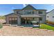 Backyard boasts a covered patio with hot tub, artificial turf, and tiered landscaping at 1280 Gentle Rain Dr, Castle Rock, CO 80109