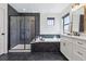 Modern bathroom featuring black marble accents, a soaking tub, a glass-enclosed shower, and dual vanities at 1280 Gentle Rain Dr, Castle Rock, CO 80109