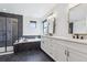 Modern bathroom featuring black marble accents, a soaking tub, a glass-enclosed shower, and dual vanities at 1280 Gentle Rain Dr, Castle Rock, CO 80109