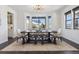 Bright dining room with large windows, modern chandelier, and stylish dark wood furniture at 1280 Gentle Rain Dr, Castle Rock, CO 80109