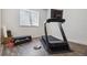 This is an exercise room with a modern treadmill and weight set with a light-filled window at 1280 Gentle Rain Dr, Castle Rock, CO 80109