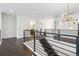 Well-lit hallway with modern railings, hardwood floors, and views into the adjacent rooms at 1280 Gentle Rain Dr, Castle Rock, CO 80109