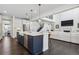 Spacious kitchen with a large island, seating, and views of living room and staircase at 1280 Gentle Rain Dr, Castle Rock, CO 80109