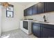 Laundry room with cabinetry, sink, and patterned flooring at 1280 Gentle Rain Dr, Castle Rock, CO 80109
