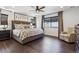Spacious main bedroom with a king bed, wood floors, a ceiling fan, and neutral decor at 1280 Gentle Rain Dr, Castle Rock, CO 80109