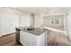 Open-concept kitchen and living room with wood flooring, natural light, stainless steel dishwasher, and ceiling fan at 2997 Pershing St, Strasburg, CO 80136