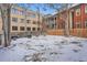Fenced backyard with snow-covered lawn and mature trees, great for outdoor enjoyment at 125 E 11Th Ave # 2, Denver, CO 80203