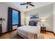 Cozy bedroom with hardwood floors, ceiling fan, and blue accent wall at 125 E 11Th Ave # 2, Denver, CO 80203