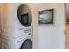 Efficient laundry area with a stacked washer and dryer next to a decorative wall hanging at 125 E 11Th Ave # 2, Denver, CO 80203