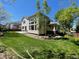 Bright backyard featuring a well-maintained lawn, trees, and back of the house with big windows and a walk-out patio at 5352 Brookside Dr, Broomfield, CO 80020